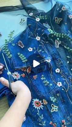 someone is using scissors to sew on a jean jacket