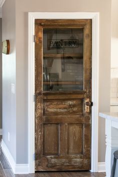 an old wooden door with glass on the front and side panels, in a kitchen