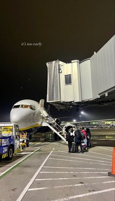 an airplane is parked at the airport with people getting off and on it's stairs