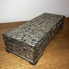 an ornate metal box sitting on top of a wooden table