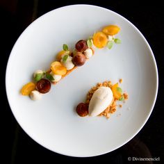 a white plate topped with food on top of a black table next to a knife and fork