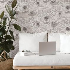 a laptop computer sitting on top of a white couch next to a potted plant