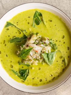 a white bowl filled with green soup and garnish