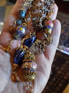 a person is holding several different necklaces in their hand