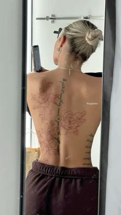 a woman is looking at her back in the mirror