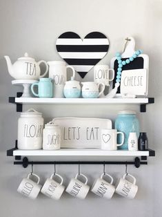 two shelves with coffee mugs, tea cups and other items on top of them