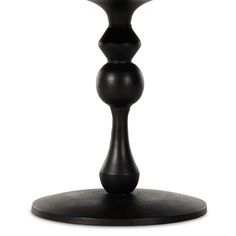 a black vase sitting on top of a wooden table