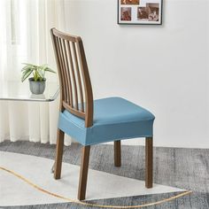 a blue chair sitting on top of a rug next to a table with a potted plant