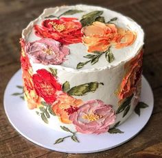 a white cake with red and orange flowers on it