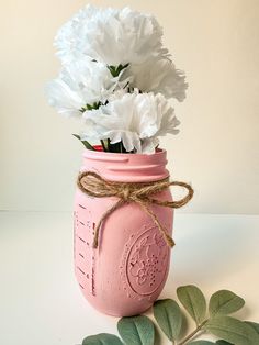 a pink mason jar filled with white flowers