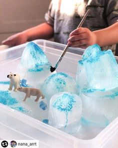 a child is painting ice with blue and white paint