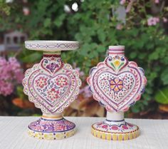 two colorful vases sitting on top of a table