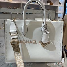 Michael Kors Mirella Medium East West Pebbled Leather Tote Shopper Bag Mk Ew Optic White Nwt Authentic Crafted From Pebbled Leather In A Structured Silhouette, The Mirella Tote Features Our Iconic Brand Lettering And A Polished Logo Charm For An Ultra-Luxe Finish. With Sleek Top-Handles And A Woven Crossbody Strap, This Bag Will Be Your New Daytime Go-To. Wear It With Denim And A Classic White Shirt. Tote Bag Pebbled Leather 100% Leather Trim: 60% Polyurethane/20% Cotton/20% Polyester Gold-Tone Brand Lettering, Handbag Essentials, Classic White Shirt, Michael Kors Tote Bags, Carryall Tote, Large Handbags, Tote Bag Purse, Zipped Bag, Medium Tote