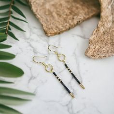 Experience sleek simplicity with our glass seed bead hook earrings. This chic linear design adds a subtle yet edgy accent to your look, featuring delicate black and gold seed beads. Elevate your style with minimalist flair. Minimalist Beaded Drop Earrings, Minimalist Beaded Dangle Earrings, Minimalist Everyday Dangle Beaded Earrings, Minimalist Tiny Beads Drop Earrings, Minimalist Drop Earrings With Tiny Beads, Minimalist Dangle Earrings With Tiny Beads, Linear Design, Gold Dangle Earrings, Beach Boho