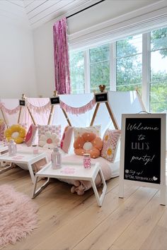 a room with pink and yellow decorations on the walls, tables and chairs in front of a sign that says welcome to lie's party