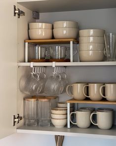 the shelves are filled with dishes and cups