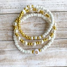 ♥ This white and gold custom letter bead stack bracelet set will level up your style and make your outfit pop! Wear one as a statement piece or the whole stack! These are so trendy right now! ♥ These are perfect for: ~ Stacking with other bracelets ~ Gifts for all ages ~ Party Favors or Stocking Stuffers ~ Beachwear/Poolwear ♥ This listing includes the set of 3 bracelets shown. To purchase multiple sets, adjust the quantity at checkout. These beaded bracelets are made with 6/0 seed beads, 7mm le Trendy White Custom Name Jewelry, Trendy Stackable White Friendship Bracelets, White Stackable Name Bracelet For Friendship, Trendy White Stackable Friendship Bracelets, Trendy White Stretch Bracelet With Custom Name, Trendy White Stackable Name Bracelet, Trendy White Beaded Bracelets With Custom Name, Trendy White Jewelry With Letter Beads, Trendy White Beaded Bracelets With Letter Beads