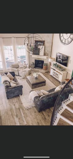 a living room filled with lots of furniture and a spiral staircase leading up to the second floor