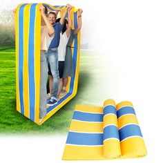 two people are standing in an inflatable tent on the grass with their arms around each other