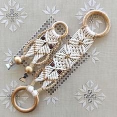 the beaded keychain is hanging on a tablecloth with white and brown beads