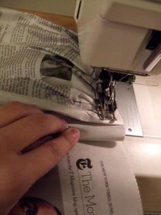 someone is using a sewing machine to sew on some paper towels that have been folded over them