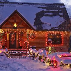 a house covered in christmas lights with snow on the ground