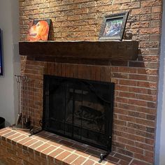 a brick fireplace in a living room next to a flat screen tv on the wall