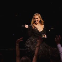 a woman sitting on top of a stage holding a microphone