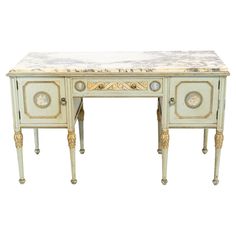 an antique desk with marble top and gold trimmings on the legs, painted in white