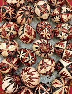 many red and white decorated eggs are on the table next to each other in rows