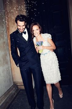 a man in a tuxedo standing next to a woman