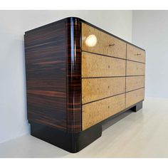 an art deco sideboard made out of wood and black lacquer with a light on top