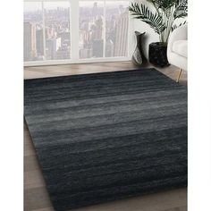 a black and gray rug in a living room next to a window with city view