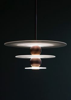 three circular lights hanging from the ceiling in a dark room