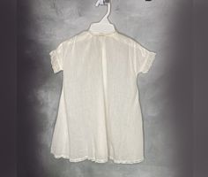 A white cotton baby dress with short banded sleeves. Lace accents the cuffs, hem and neckline. It closes with a snap at the back neck and has a pleat in the front. Very good condition (a few small breaks in the hem lace; the snap has been added). Hand or gentle machine wash. Size 6 to 12 months. Catalog # 5849 Cotton Baptism Dress With Short Sleeves For Daywear, Cotton Short Sleeve Baptism Dress, Classic Short Sleeve Cotton Baptism Dress, Cotton Baptism Dress With Short Sleeves, White Short Sleeve Baptism Dress For Daywear, White Baptism Dress With Short Sleeves For Daywear, White Vintage Baptism Dress For Daywear, Vintage White Baptism Dress, Vintage Cotton Baptism Dress