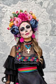 a woman with makeup and flowers in her hair wearing a costume that has been made to look like a skeleton