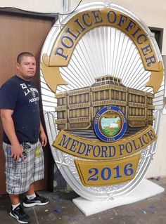 a man standing next to a police sign