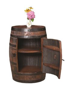 a vase with flowers on top of a wooden barrel