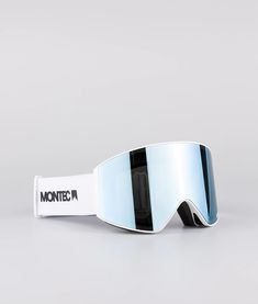 a pair of ski goggles sitting on top of a white table next to a gray wall