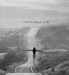 a woman standing on top of a road with her arms outstretched