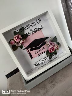 a graduation card with pink flowers in a shadow box