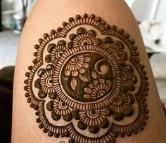 a henna tattoo on the back of a woman's arm, with an intricate design