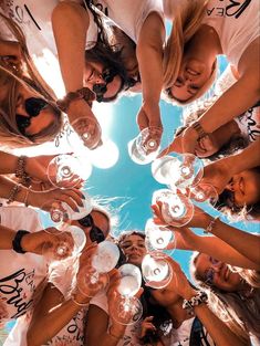 a group of women standing in a circle holding wine glasses