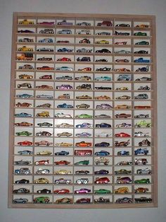 a large display of cars on a wall in a room with white walls and wood trimming