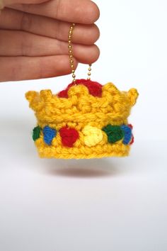 a crocheted crown ornament being held by a hand