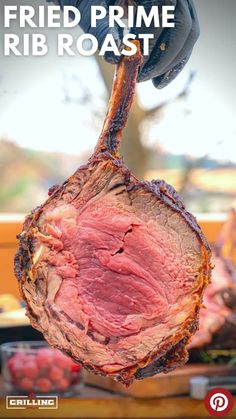 a piece of meat is being held up by a person's hand with the words fried prime rib roast on it