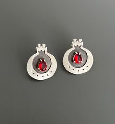 "About this Item: these sterling silver handcrafted pomegranate earrings are truly unique. the pomegranate fruit is often seen as a symbol of femininity and fertility, and these earrings feature a stunning red crystal that complements the fruit's vibrant color. not only are they stylish,but they are also comfortable to wear and add a pop of color to even the simplest outfits.  Materials: 925 Sterling silver, red Crystal Weight: 0.20 oz ( 5.9 gr )  I believe that jewelry is not just a decorative accessory, but a meaningful and profound object that carries deep beauty and significance within. The true beauty originates in our minds and thoughts before it is reflected in our appearance, and that is precisely why I chose the name Baavaar for my brand. Baavaar means \"believe\" in my native Far Pomegranate Earrings, Pomegranate Jewelry, Pomegranate Fruit, Dainty Studs, Red Crystals, True Beauty, Gift Birthday, Fertility, Jewelry Branding