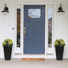 a blue front door with two planters on the side and numbers painted on it