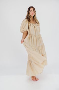 Gently feminine, the Eva Puffed Sleeve Maxi Dress is the perfect choice for the fashion-forward woman. Featuring dramatic balloon sleeves, an elastic neckline for easy wear (and easy nursing!), and tiers of ruffles for a charming yet sophisticated look, this elegant maxi dress is designed with style and comfort in mind. Its relaxed fit makes it a gorgeous choice for expecting mamas. FIT: Runs slightly oversized - very relaxed fit. Your true size will accommodate most baby bumps. MATERIAL: 91% Po Feminine Voluminous Puff Sleeve Dress With Balloon Sleeves, Beige Puff Sleeve Dress For Brunch, Beige Puff Sleeve Midi Dress For Brunch, Spring Billowy Puff Sleeve Dress With Lantern Sleeves, Solid Color Puff Sleeve Dress With Smocked Bodice, Billowy Bishop Sleeve Puff Sleeve Dress For Brunch, Billowy Bishop Sleeve Puff Dress For Brunch, Billowy Puff Sleeve Dress With Gathered Lantern Sleeves, Billowy Lantern Sleeve Dress With Gathered Puff Sleeves