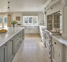 a large kitchen with lots of counter space and white cabinets on both sides of the room